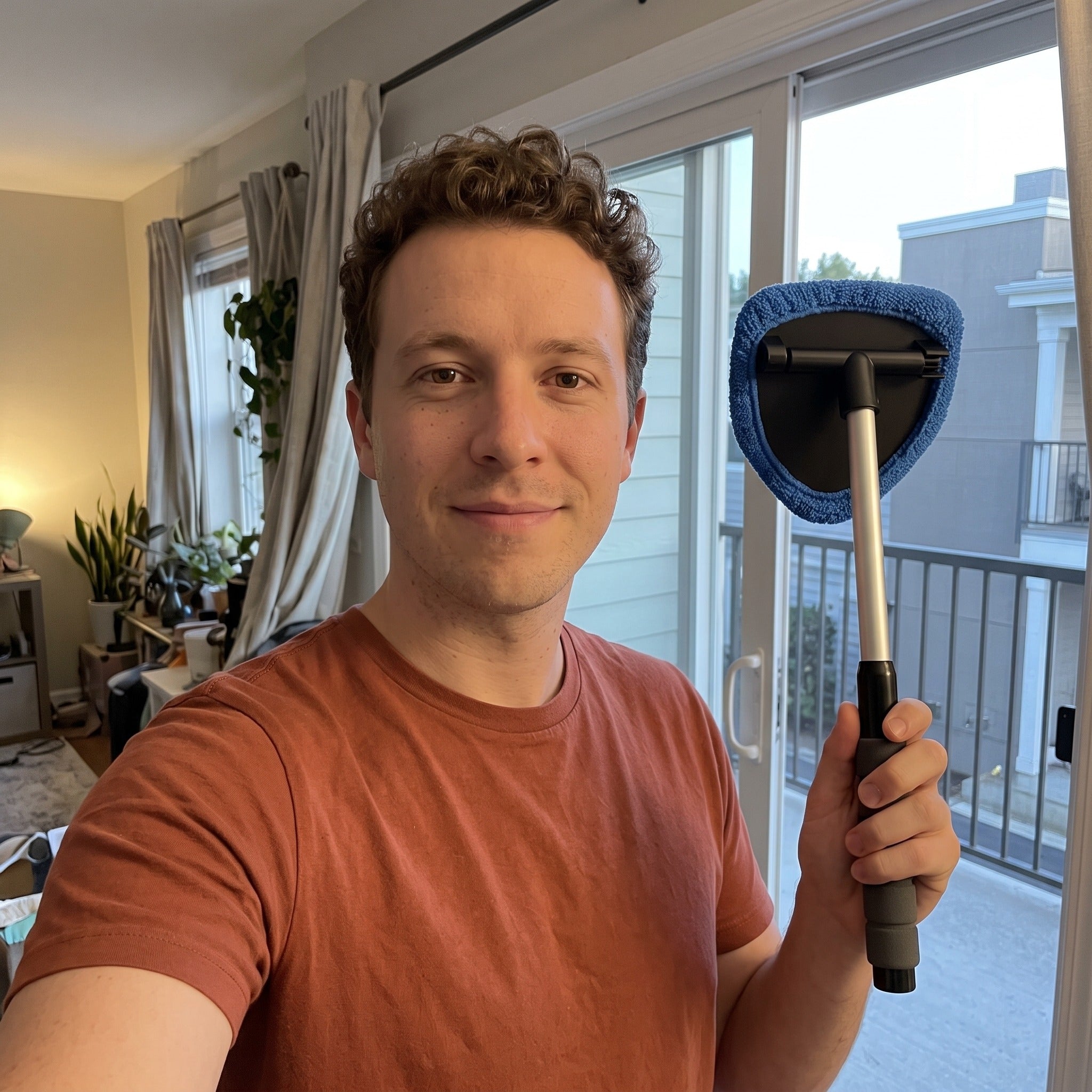 Ben taking a selfie beside a balcony glass door after cleaning